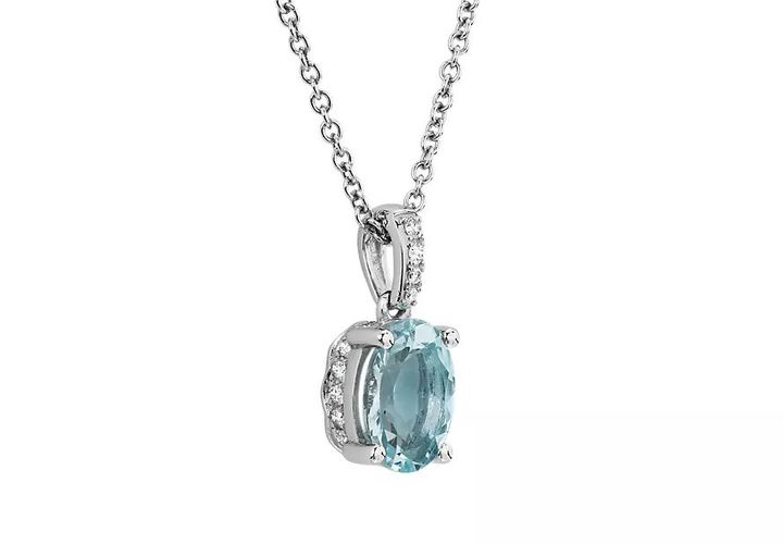 An oval aquamarine gemstone pendant in a white gold setting with diamond pavé bail